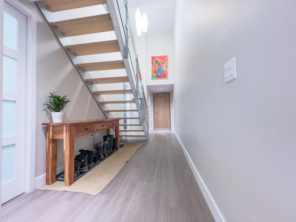 Slimline real-oak boot-bench under an open-tread staircase in a Peel hallway.